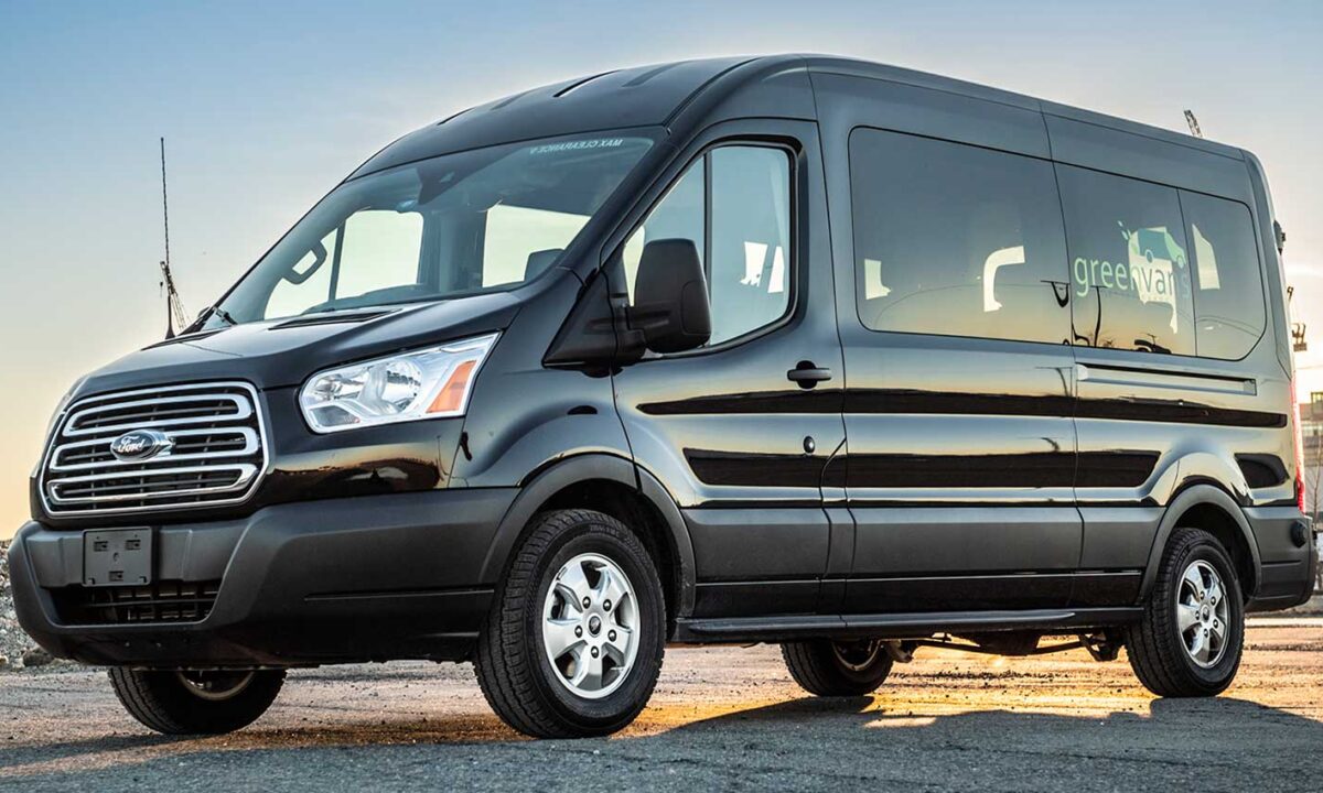 Black Ford 15 passenger midroof rental van with Greenvans logo on side