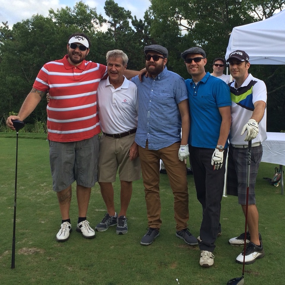 Five male golfers standing on the green