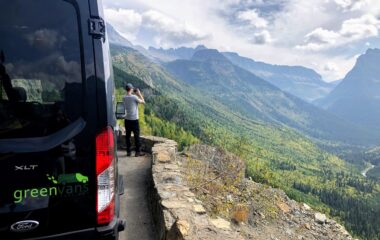 A male tourist overlooking Mammoth Mountain outside of his Ford 15 passenger van rental from Greenvans