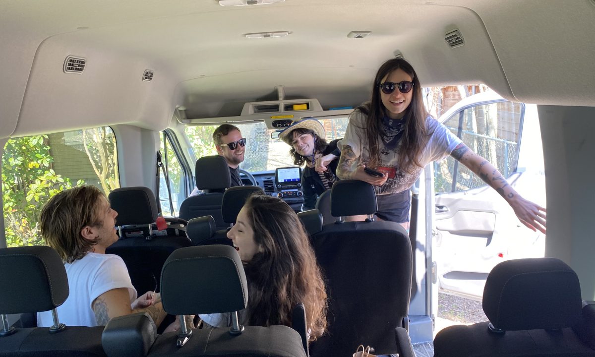 A family of five taking a passenger van on a family road trip