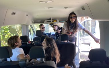 A family of five taking a passenger van on a family road trip