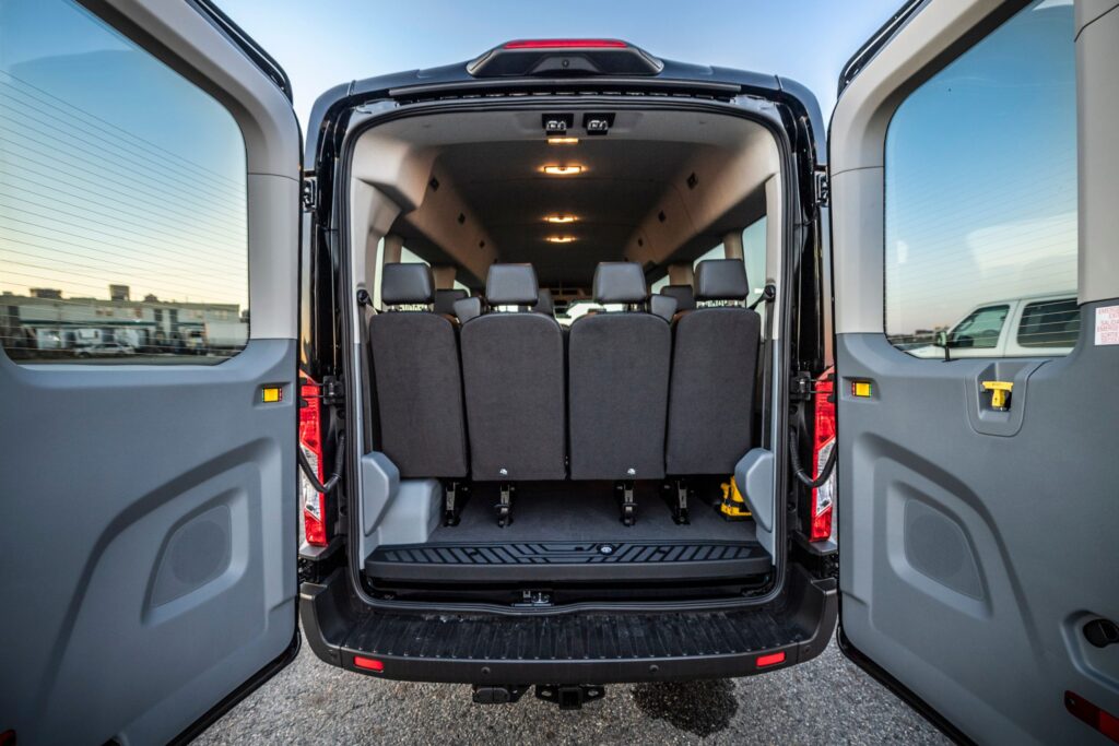 Rear interior view of Ford Transit 15 passenger van with all rows installed in van, rentable with Green Vans