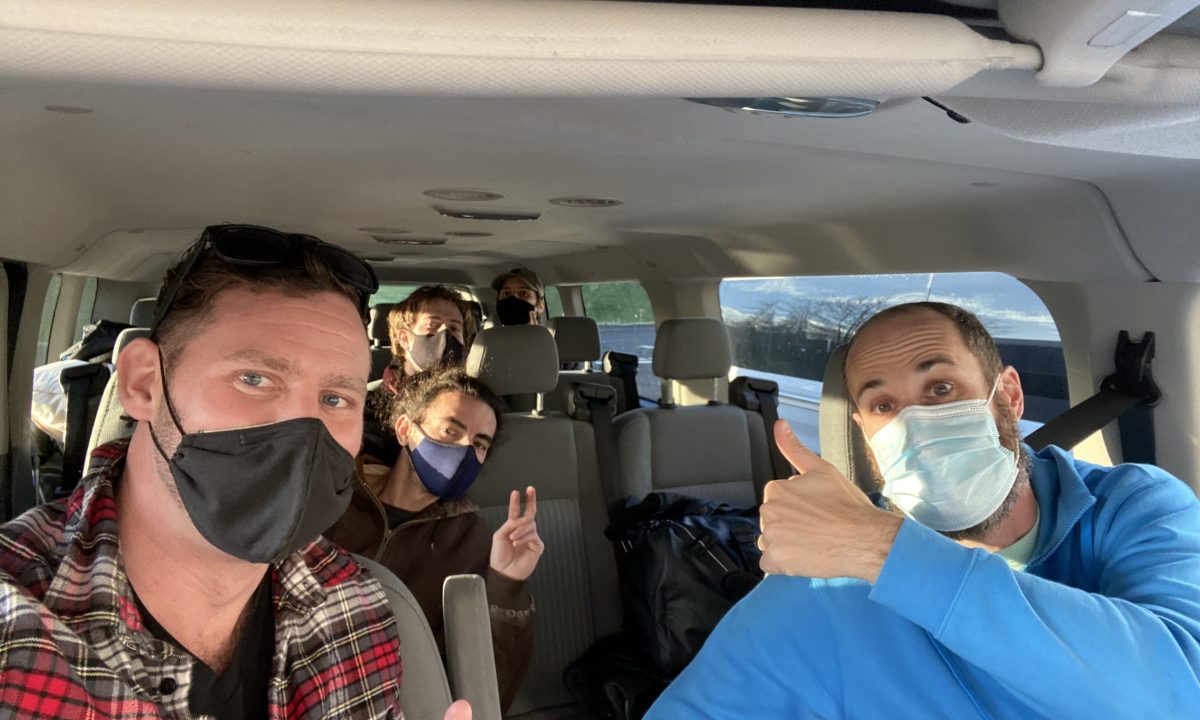 Andy and Anthony with team wearing masks sitting in a Ford 15 passenger transit van