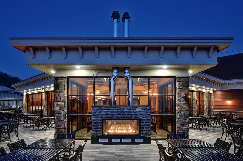 Patio of ski resort in Pennsylvania with tables and gas fireplace to visit with a large group in a rental van.
