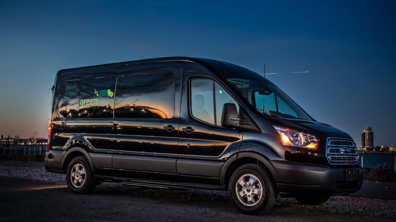 Side image of a Greenvans 15 passenger van Ford Transit 350 XLT with Greenvans logo