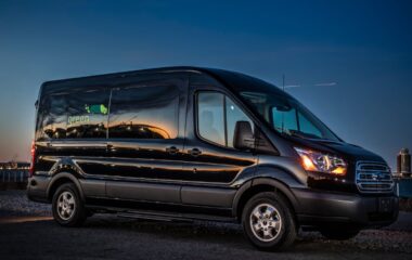 Side image of a Greenvans 15 passenger van Ford Transit 350 XLT with Greenvans logo