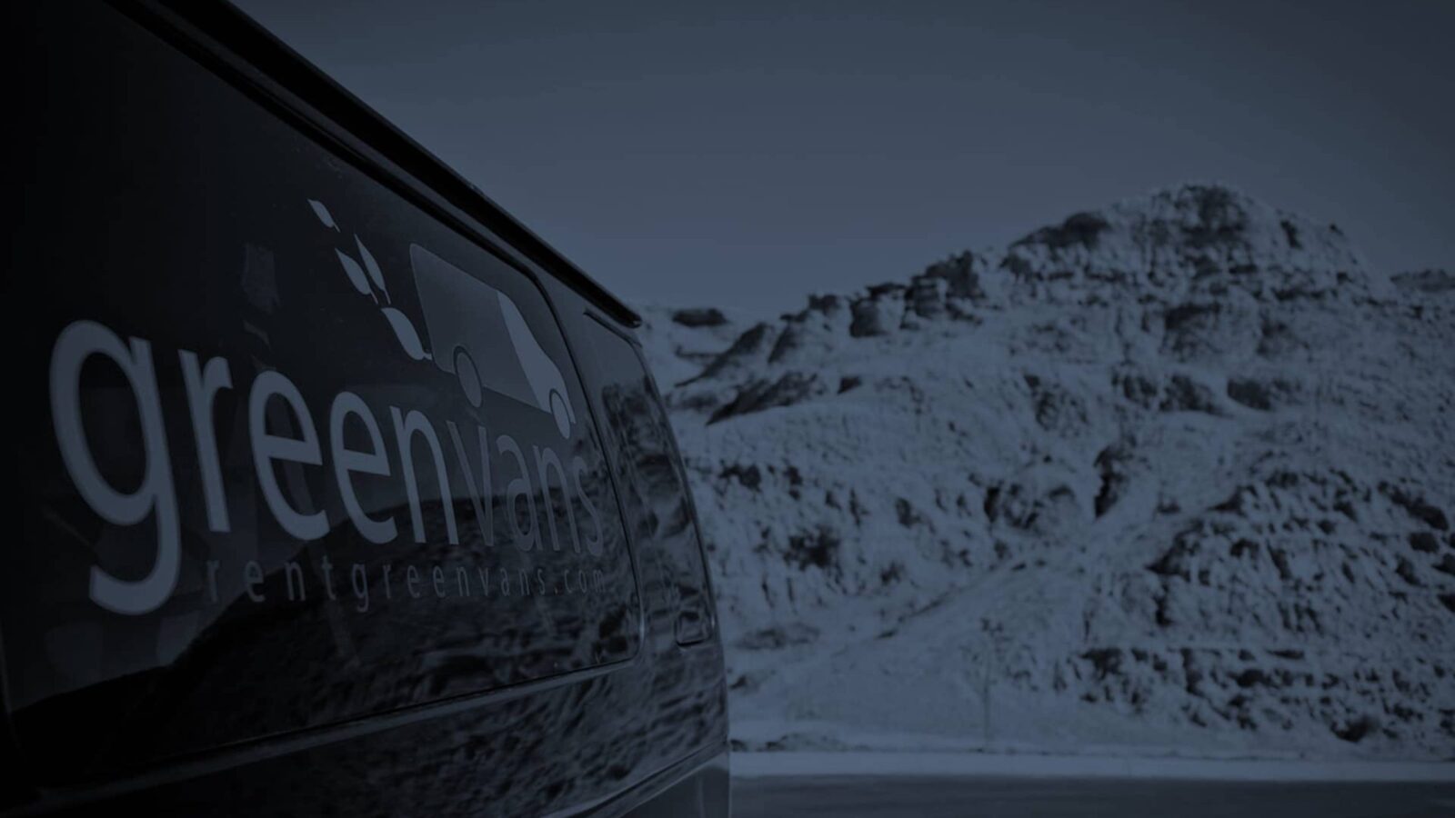 side image of Greenvans 15-passenger van Ford Transit 350 XLT with snowy mountains in background