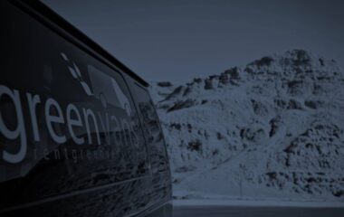 side image of Greenvans 15-passenger van rental Ford Transit 350 XLT with snowy mountains in background