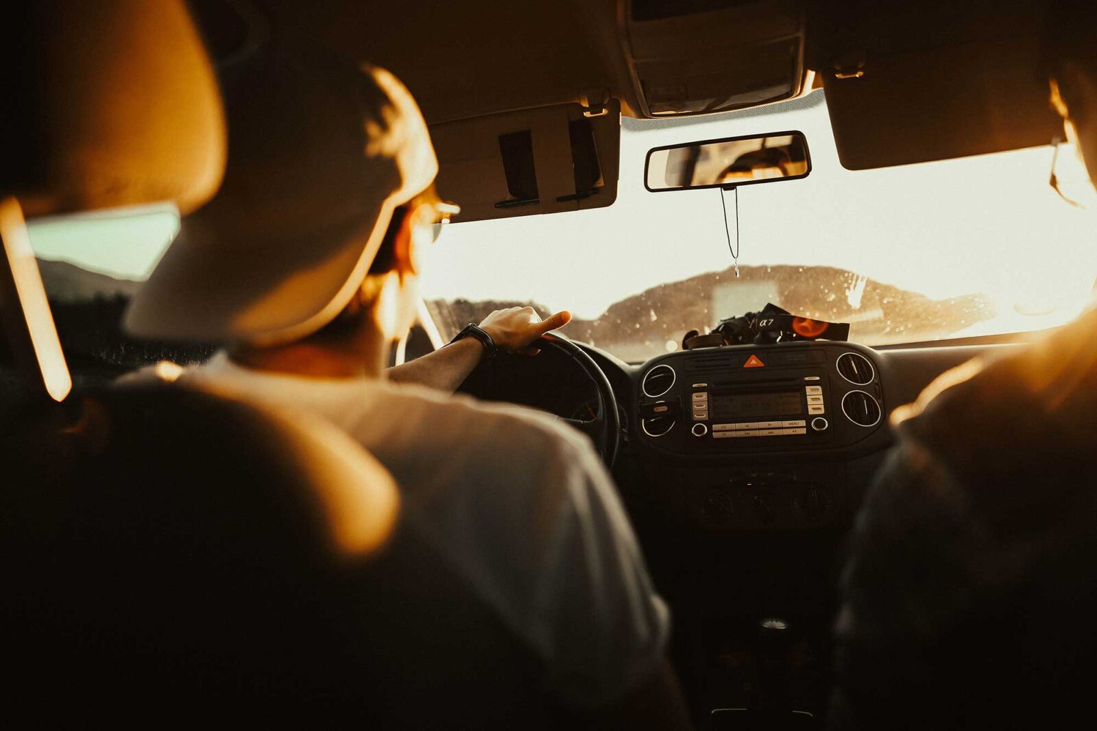 Man wearing baseball cap backwards driving a Greenvans 15 passenger rental van