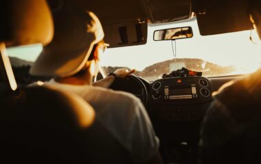 Man wearing baseball cap backwards driving a Greenvans 15 passenger rental van