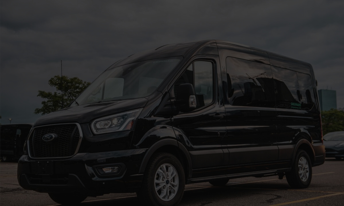 Side image of a Greenvans 15-passenger van rental Ford Transit 350 XLT with snowy mountains in background